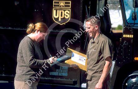 UPS delivery  courier with customer signing electronic computer.  MR
