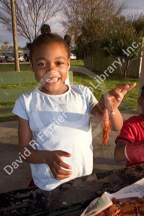 African american girls eating crawfish and corn on the cob in New Orleans, Louisiana.