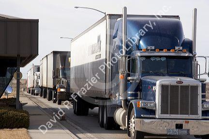 Long haul trucks line up a weigh station.