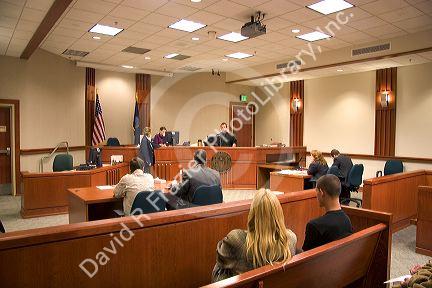 Court room scene with  in Boise, Idaho.  Criminal defendant  and lawyer sit with backs to camera.