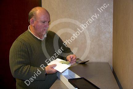 Man putting cash into a safe deposit box.