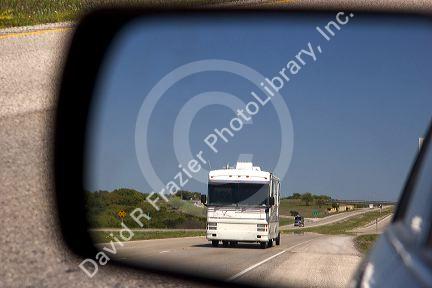 A recreational vehicle seen through aan automobile rear view mirror on the Interstate 10 in West Texas.