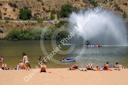 Adults and children play on the beach and in the water at Sandy Point near Boise, Idaho.