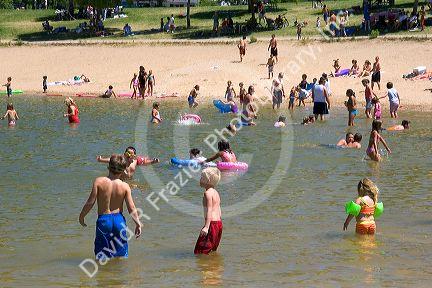Adults and children play on the beach and in the water at Sandy Point near Boise, Idaho.