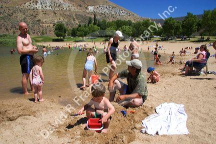 Adults and children play on the beach and in the water at Sandy Point near Boise, Idaho.