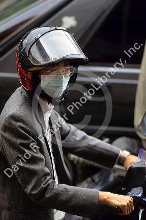 A man wearing a face mask to filter pollution rides a scooter in Taipei, Taiwan.