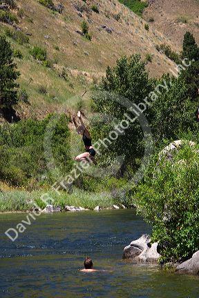 A girl jumps off of a rock into the Payette River near Horseshoe Bend, Idaho.