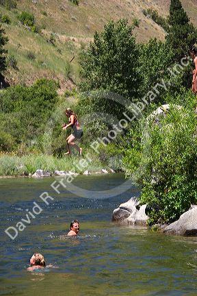 A girl jumps off of a rock into the Payette River near Horseshoe Bend, Idaho.