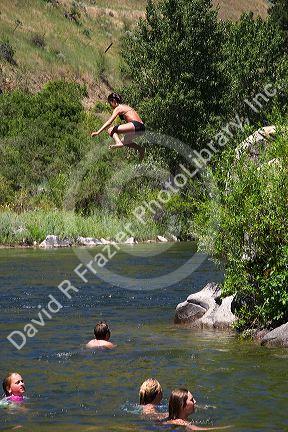 A girl jumps off of a rock into the Payette River near Horseshoe Bend, Idaho.