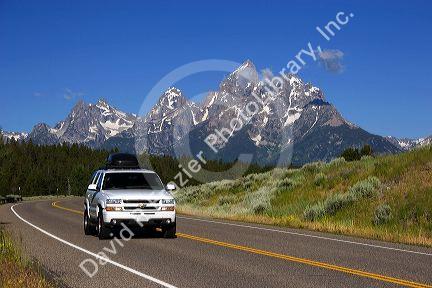 Automobile driving on a highway near the Grand Teton Mountains, Wyoming.