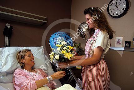 Volunteer candy striper delivers flowers to a hospital patient.