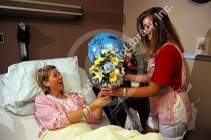Volunteer candystriper delivers flowers to a hospital patient.