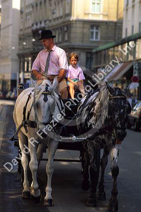 Man with young boy on a carriage ride in Vienna, Austria.