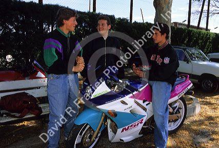 French teen boys with motorcycles talk in Paris, France.