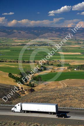 A long haul truck on the highway with farms and agriculture at Ellensburg, Washington.