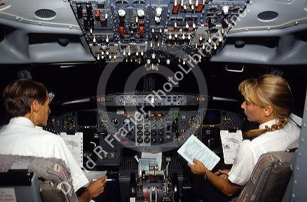 Male pilot and female co-pilot in the cockpit of a Boing 737 commercial airplane.