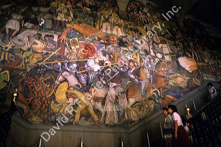 Visitors look at a Diego Rivera mural at the National Palace in Mexico City, Mexico.