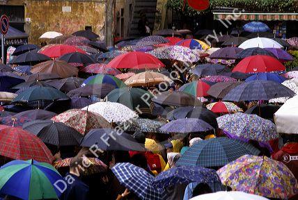 A crowd of people using umbrellas at a festival in Camogli, Italy.