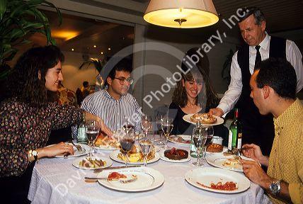 A waiter serves tapas to a table in Barcelona, Spain.