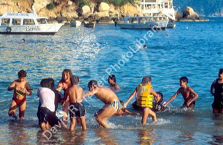 Hispanic family swimming at the beach in Acapulco, Mexico.