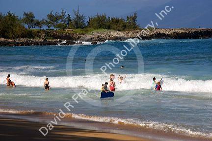 Boogie boarding on waves in the pacific ocean off the island of Maui, Hawaii.