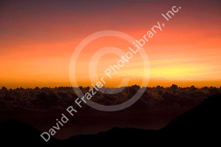 Sunrise above the clouds on the island of Maui, Hawaii atop Mount Haleakala.