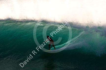 Surfing on waves in the pacific ocean off the island of Maui, Hawaii.
