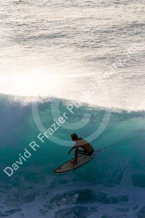 Surfing on waves in the pacific ocean off the island of Maui, Hawaii.