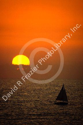 A sailboat at sunset off Huntington Beach in California.