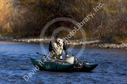 Fly fisherman on the South Fork of the Boise River in Idaho using a small pontoon boat.