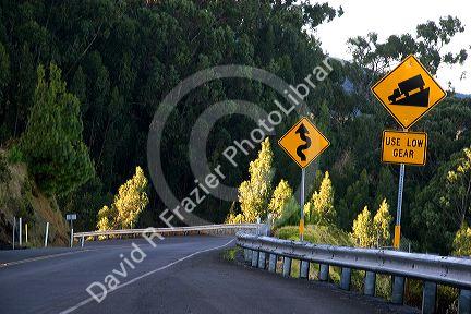 Road signs warning of corners and steep grade at Mount Haleakala on the island of Maui, Hawaii.