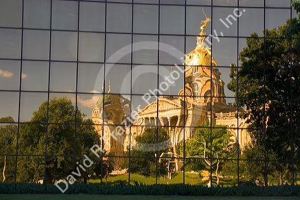 A reflected and distorted view of the capitol building in Des Moines, Iowa in the glass of the Henry A. Wallace office building.