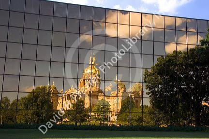 A reflected and distorted view of the capitol building in Des Moines, Iowa in the windows of the Henery A. Wallace office building.