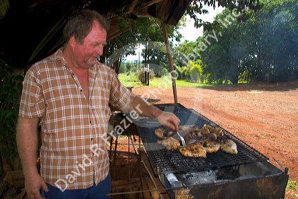 A man grilling chicken in Argentina.