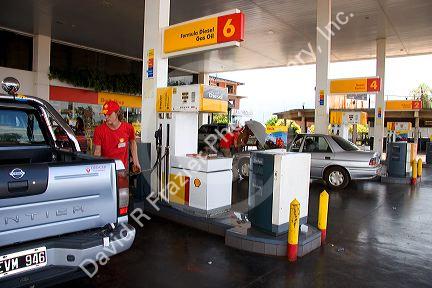 Worker pumping gas at a gas station in Argentina.
