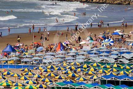 Colorful umbrellas and cabanas accent beach scene at Mar del Plata, Argentina.