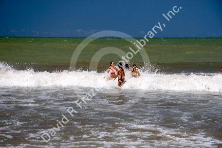 Girls play in the surf at Gesell, Argentina.