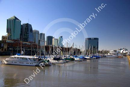 Modern offices tower above the low red brick warehouses and boats docked at Puerto Modero in Buenos Aires, Argentina.