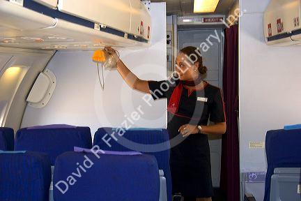Flight attendant demonstrating how to use oxygen during safety briefing.