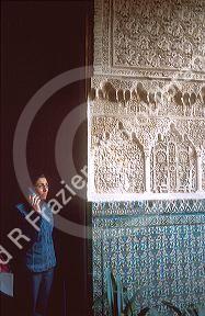 Female tourist listens to tour translation at Alcazar in Seville, Spain.