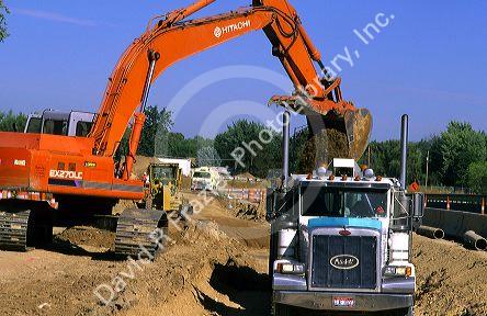 Tract mounted power shovel loads truck on a road construction site in Boise, Idaho.