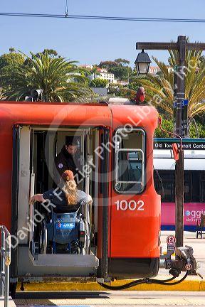Handicapped passenger boards a Trolley using a lift in San Diego, California.