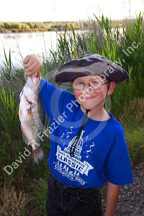 Young boy holding a bass in Idaho.