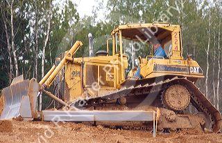Bulldozer tractor pushing dirt on highway construction project.