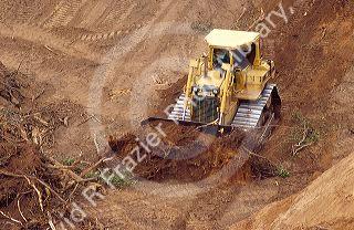 Caterpillar bulldozer moving dirt at highway construction site.