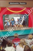 Children watch marionette puppet show.