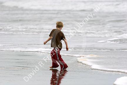 A boy plays in the ocean surf on the beach at Santa Cruz, California.