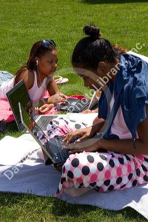 African american female students study using laptop computers on the lawn of Albion College in Michigan.