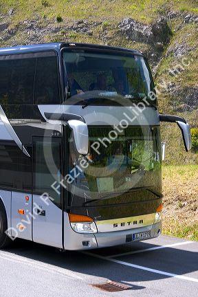 A European tour bus traveling in the Austrian Alps, Austria.