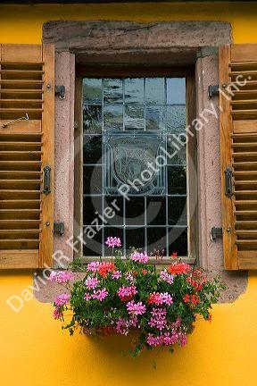 Shuttered window with etched glass and flower box at Thannenkirch, France.